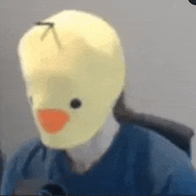 a person is wearing a yellow duck mask on their face .