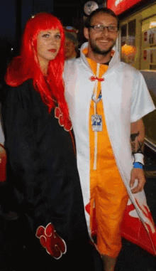 a man and a woman are posing for a picture and the woman is wearing red hair