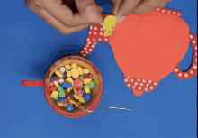 a person is holding a piece of paper with a cookie on it next to a bowl of jelly beans