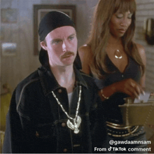 a man with a mustache is standing next to a woman wearing a black top