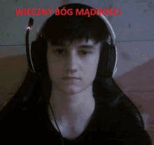 a young man wearing headphones with the words wieczny bog madrosci written in red