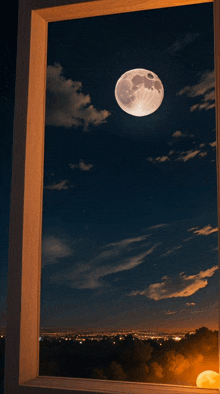 a full moon is visible through a window overlooking a city