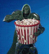 a superhero is holding a bucket of popcorn in his hands