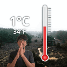 a man stands in front of a thermometer that reads 1 degrees celsius