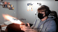 a man wearing a mask and headphones is holding a lighter in front of a sign that says mijn cijfers