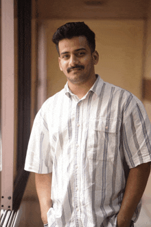 a man with a mustache wearing a striped shirt