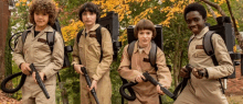 a group of young boys dressed as ghostbusters are standing next to each other holding guns