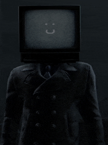 a man in a suit and tie has a tv on his head with a smiley face on it