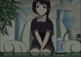 a girl sitting on a couch with a glass of water and a straw