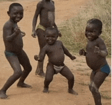 a group of young boys in underwear are dancing on a dirt road