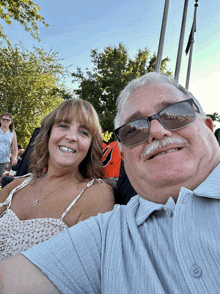 a man and woman are posing for a picture and the man has a mustache