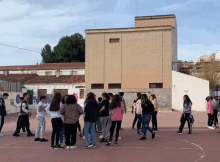 a group of people are standing in front of a building that has the letter g on the side