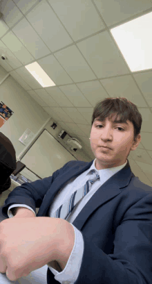 a man in a suit and tie is sitting in a room