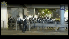 a group of police officers standing in front of a fence with a sign that says lonely dog on it