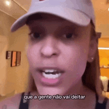 a woman wearing a hat is talking in a room and says `` que a gente não vai deitar '' .