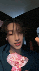 a young man in a car with a bouquet of pink lollipops