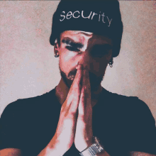 a man wearing a black beanie with the word security on it