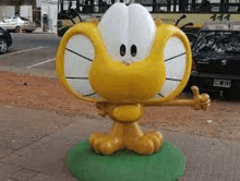 a statue of a cartoon cat giving a thumbs up .