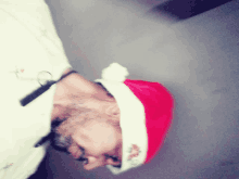 a man wearing a santa hat with a white pom pom