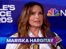 a woman is talking into a microphone with the name mariska hargitay on the bottom