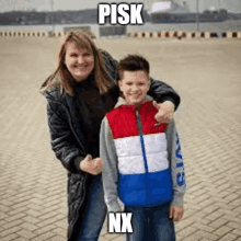 a woman and a boy are standing next to each other on a brick road .