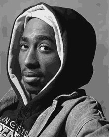 a black and white photo of a man wearing a hoodie