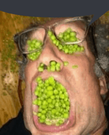 a man with glasses has peas on his face