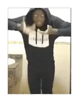 a man wearing a calvin klein hoodie is standing in front of a toilet