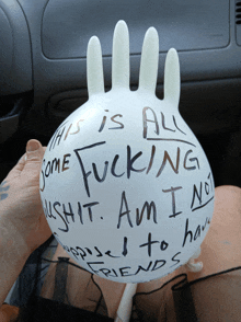 a person is holding a white ball that says " this is all some fucking "