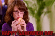 a woman with glasses is eating a sandwich with the words happy sandwich day above her