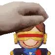 a hand is putting a stuffed toy on top of a cartoon character .