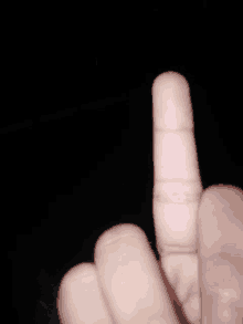 a close up of a person 's middle finger in the dark