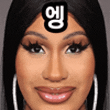 a close up of a woman 's face with a sticker on her forehead that says ' cardi b ' .