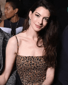 a woman wearing a leopard print top is smiling for the camera