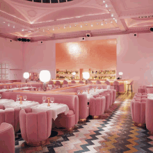 a large room with pink tables and chairs and a bar