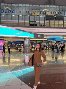 a woman stands in front of a dubai international airport