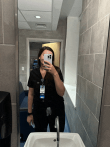 a woman taking a picture of herself in a bathroom with a name tag that says mir