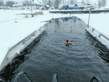 a person is swimming in a body of water with a building in the background that says ' hotel ' on it