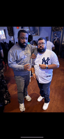 a man in a ny yankees shirt stands next to another man