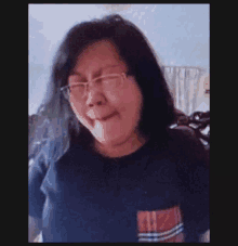 a woman wearing glasses and a black shirt is making a funny face