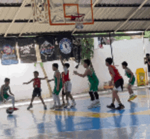 a group of young boys are playing basketball on a court with a banner behind them that says 1 on it