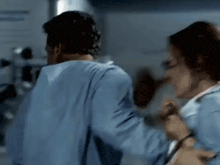 a man and a woman are standing next to each other in a hospital .