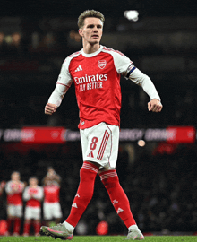 a soccer player in a red emirates fly better jersey