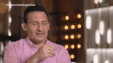 a man in a pink shirt is on a tv show called masterchef