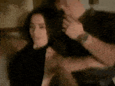 a man is brushing a woman 's hair with a hair dryer .