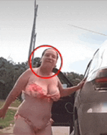 a woman in a bikini is standing next to a car with her door open .