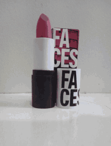 a pink lipstick is sitting next to a box that says " fa ces "