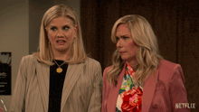 two women standing next to each other with netflix written on the bottom