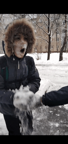 a boy with snow on his face is being thrown in the air