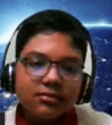 a boy wearing headphones and glasses is looking at the camera .